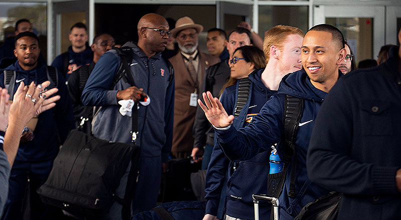 Titan community members cheer the Men's basketball team as they leave for the NCAA Tournament.