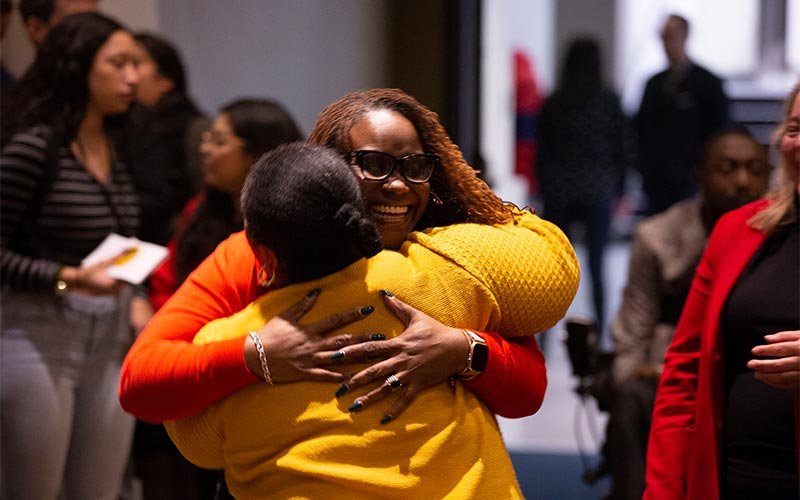 Guests hugging at the Black History Month reception