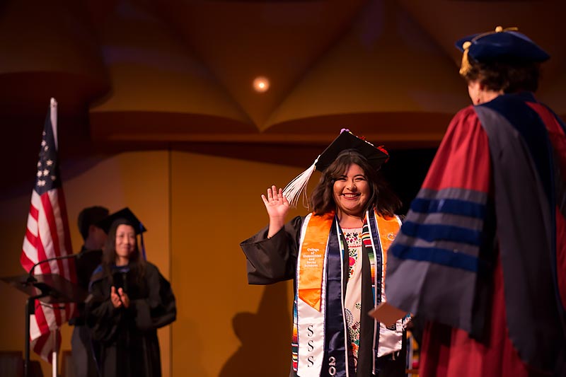 Graduating student on stage to receive her diploma.