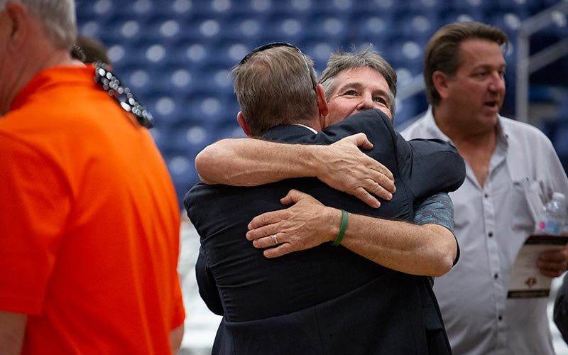 Tom Thomas '86 embraces a friend.