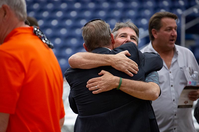 Tom Thomas '86 embraces a friend.