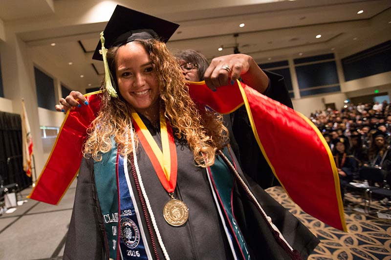A graduate receives her special sash at the Asian and Pacific Islander Graduate Recognition Ceremony.
