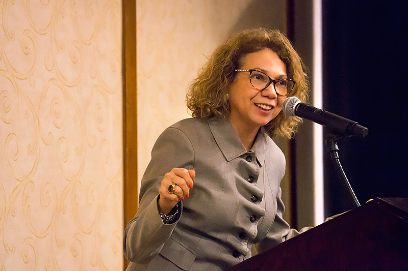 CSUF President Mildred Garcia speaking at a podium.