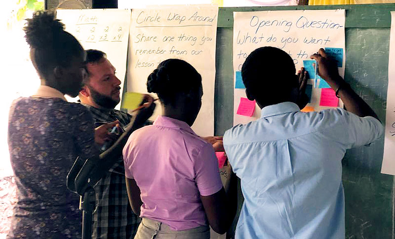 Rick Montoya with students at the whiteboard.