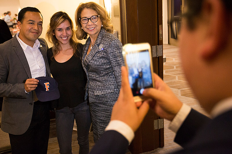Student business major Areli Sena, center, poses for a photo with keynote speaker Cesar Vargas and CSUF President Mildred García.