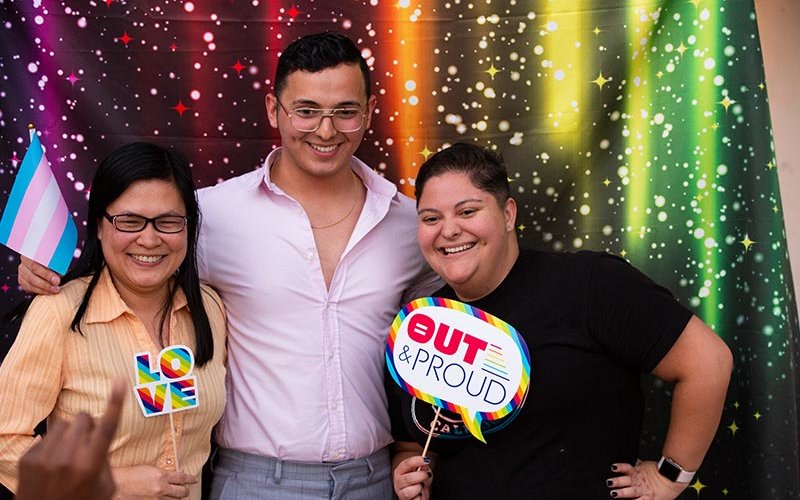 Students Thu Nguyen, Christian Aguilar and Gabi Cuna pose for a photo at the university's LGBTQ History Month celebration