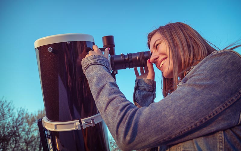 Young women looking through telescope