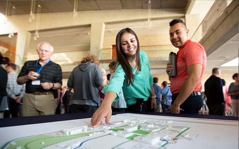 CSUF Housing Community Coordinator Jennifer Ortiz interacts with facsimiles of campus buildings in the Master Plan.