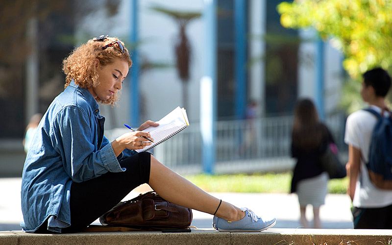 Female student studying outdoors.