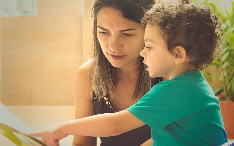 Mother reading book to child.