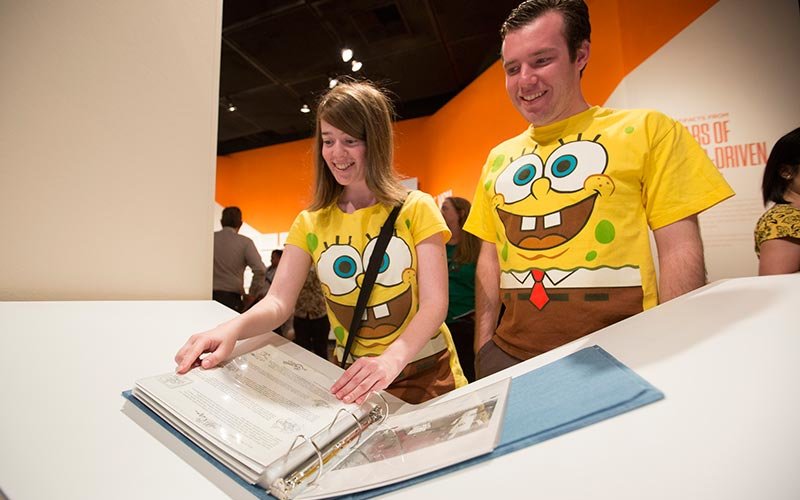 SpongeBob SquarePants super fans Sefra and Jordan Orlick browse through a binder of SpongeBob SquarePants production paraphernalia.