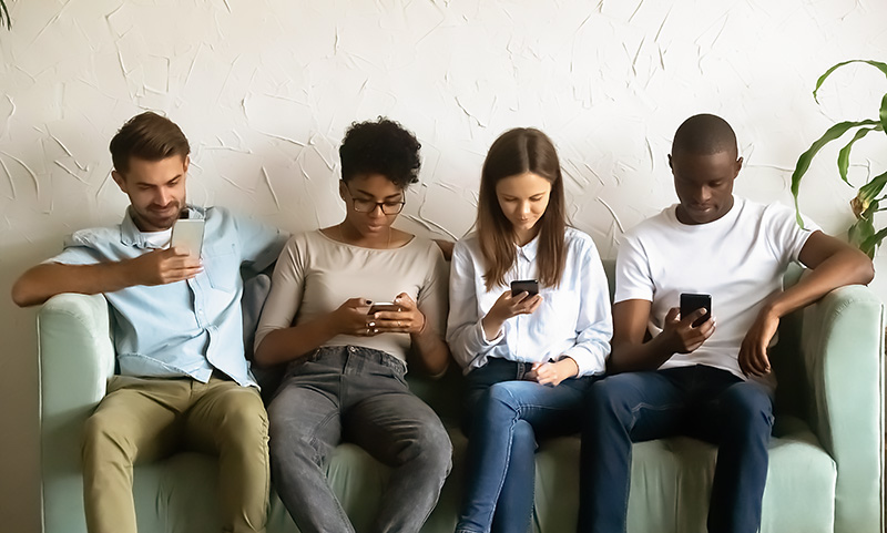 A group of young adults on their smartphones.
