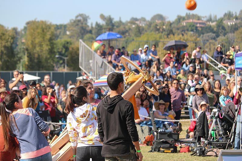 Students launching a pumpkin with custom made catapult.