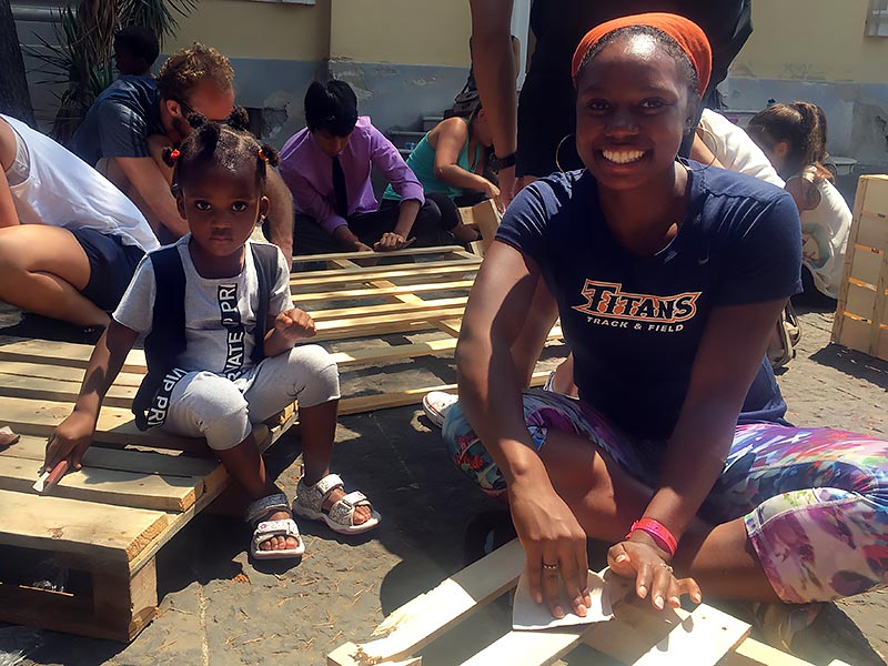 CSUF student in Italy interacting with a refugee.