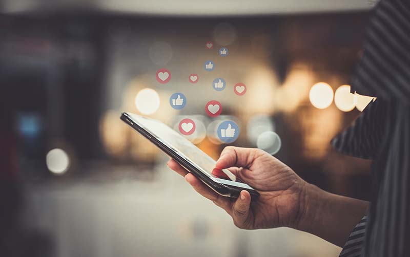 Hand using smartphone to access Social media