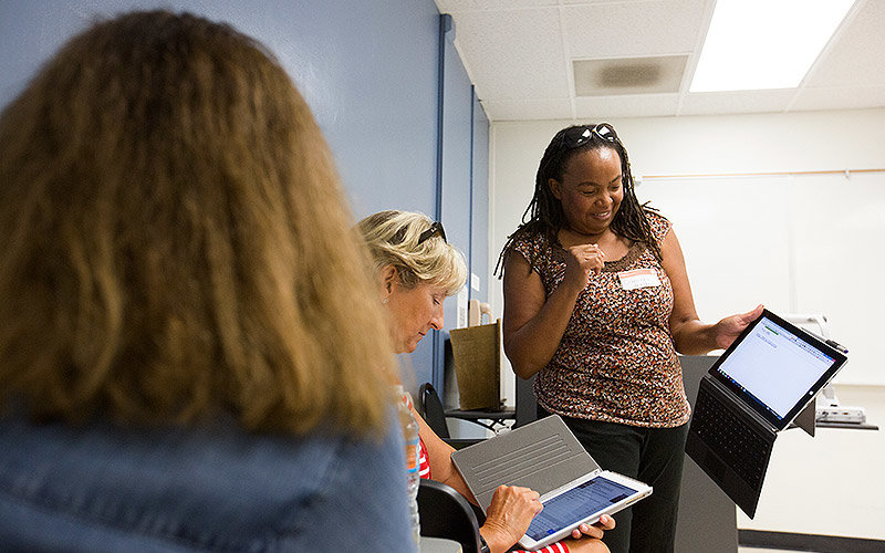 Teachers interacting with tablets.