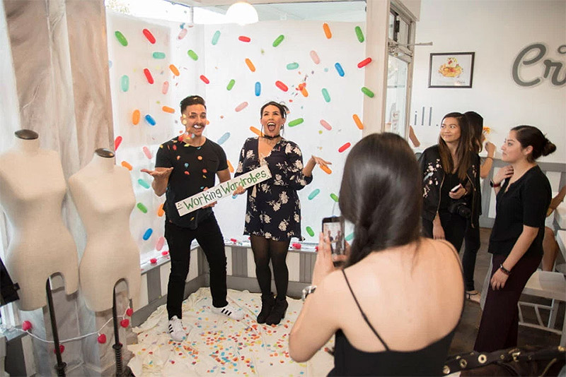 Man and a woman toss confetti in the air while onlookers smile.