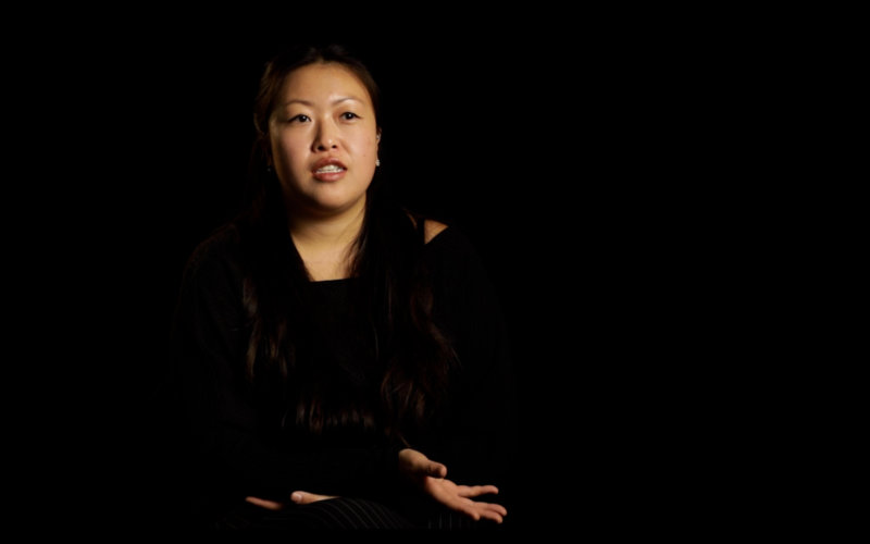 an Asian woman sitting and talking