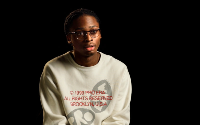 racism an young Black man in a white sweatshirt smiling anti-racism