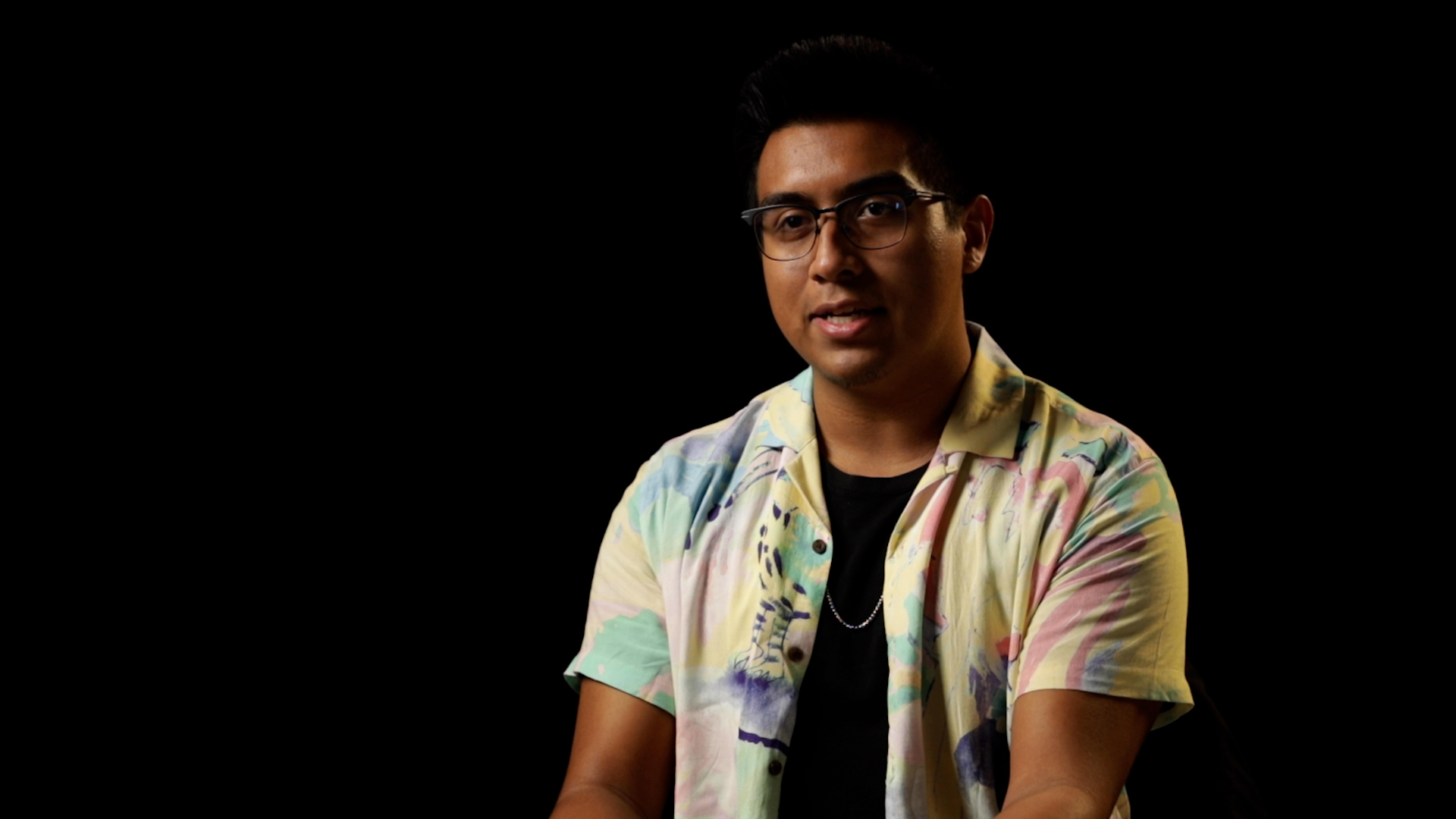 a man wearing eyeglasses sitting
