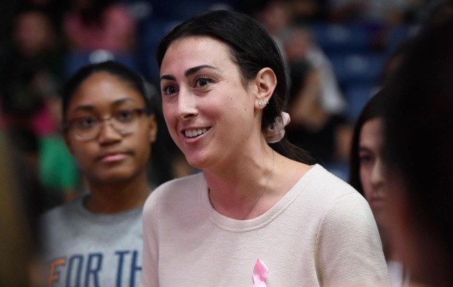 a woman wearing a pink top and smiling