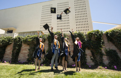 Four graduates throw their caps