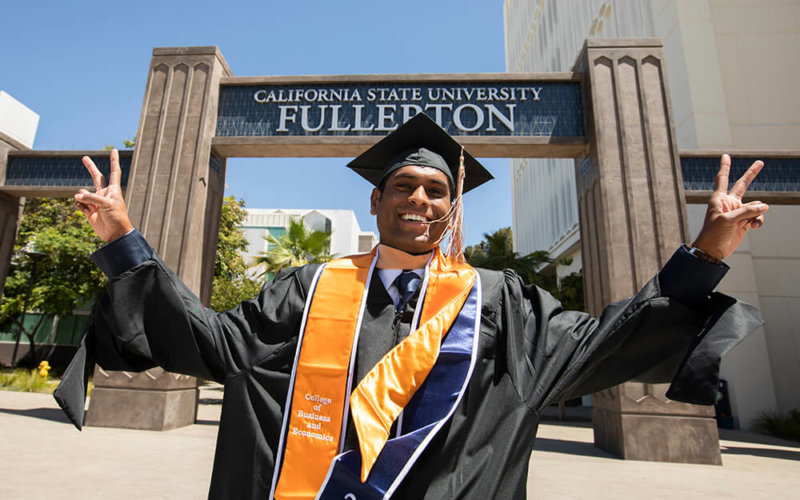 Happy graduate at campus entrance