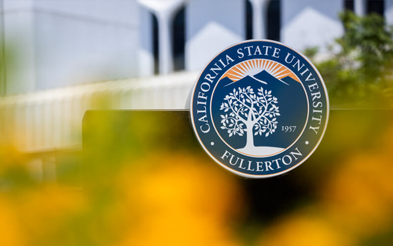 CSUF Seal framed by flowers and McCarthy Hall