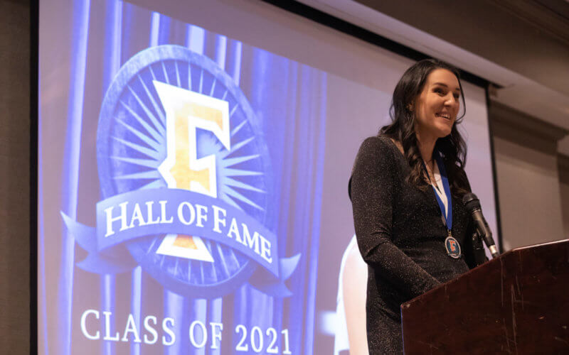 Erin (Saddler) Henry stands at podium