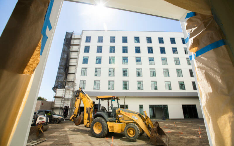 Excavator framed by Housing construction