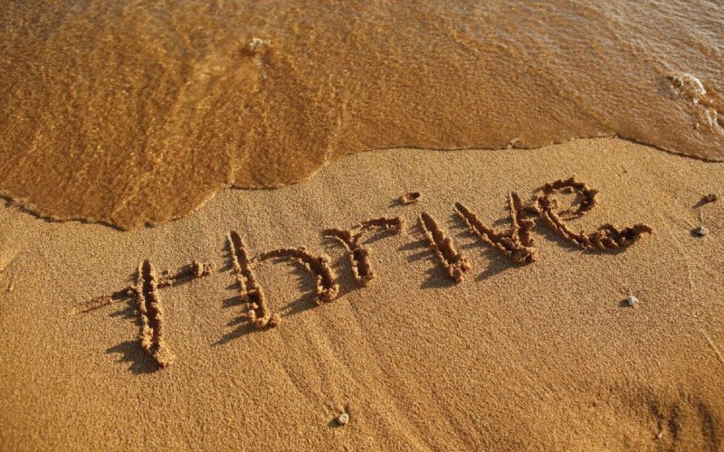 "Thrive" written in the sand