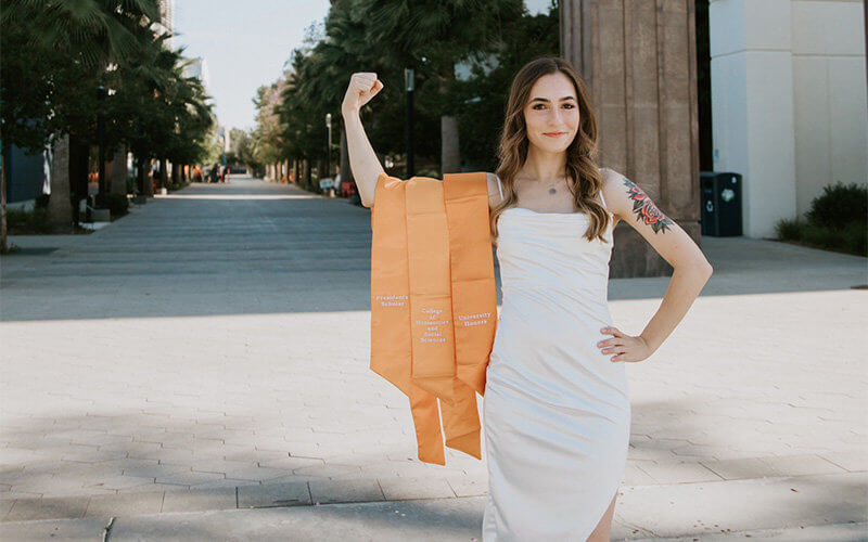 Amaris Aloise flexing with regalia stoles over her arm