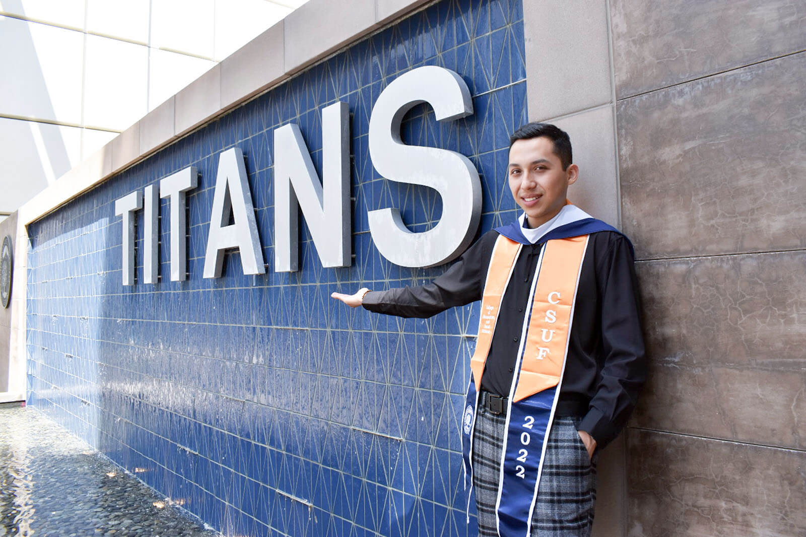 Erick Murillo poses in front of "TITANS" water feature