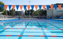 olympic size swimming pool with orange and blue flags