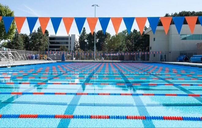 olympic size swimming pool with orange and blue flags