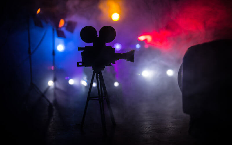 Crime movie concept. Police cars and miniature movie set on dark toned background with fog.