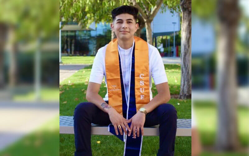 Luis Bustos sitting with regalia stole over shoulders