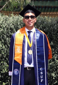 Nicholas J. Torres poses in Commencement regalia