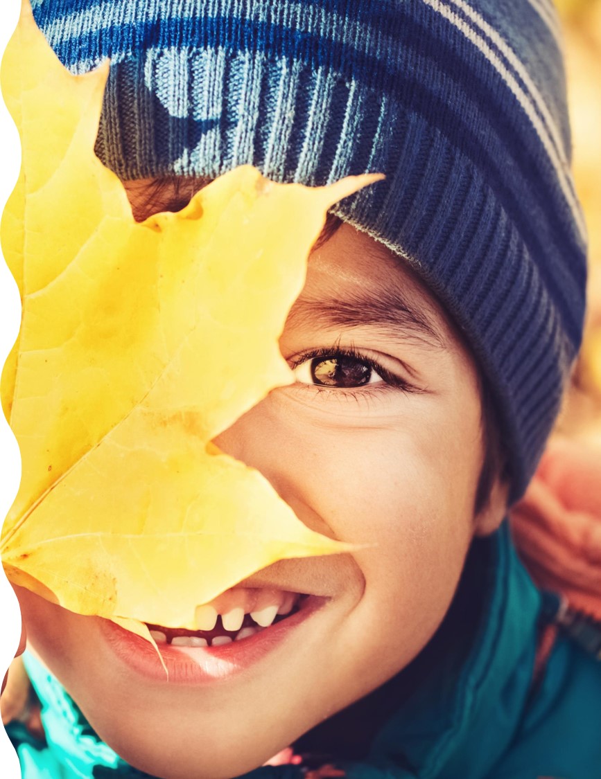 Child holding a leaf up to their eye