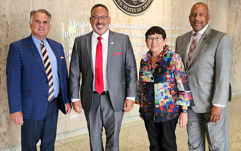 Cal State Fullerton President Fram Virjee, from left, U.S. Secretary of Education Miguel Cardona, CSU Chancellor Jolene Koester and CSU Dominguez Hills President Thomas Parham.