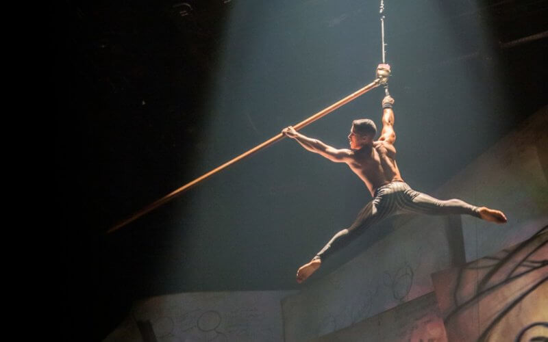 Acrobat swings from rope
