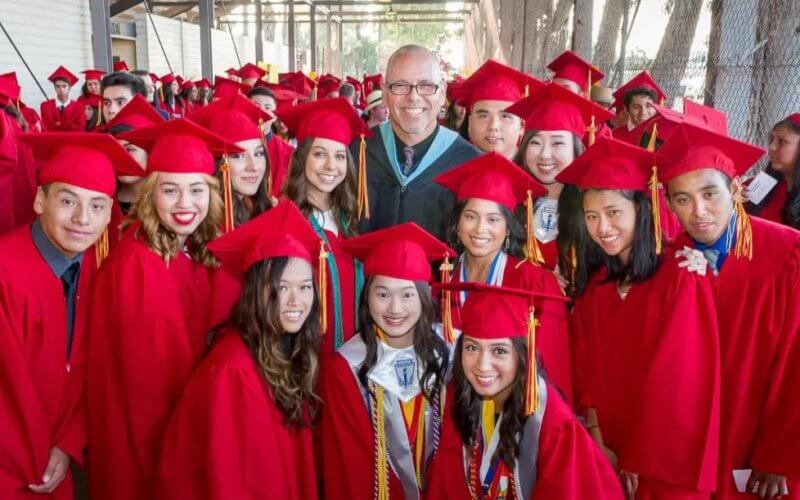 Educator John Briquelet with Graduating students