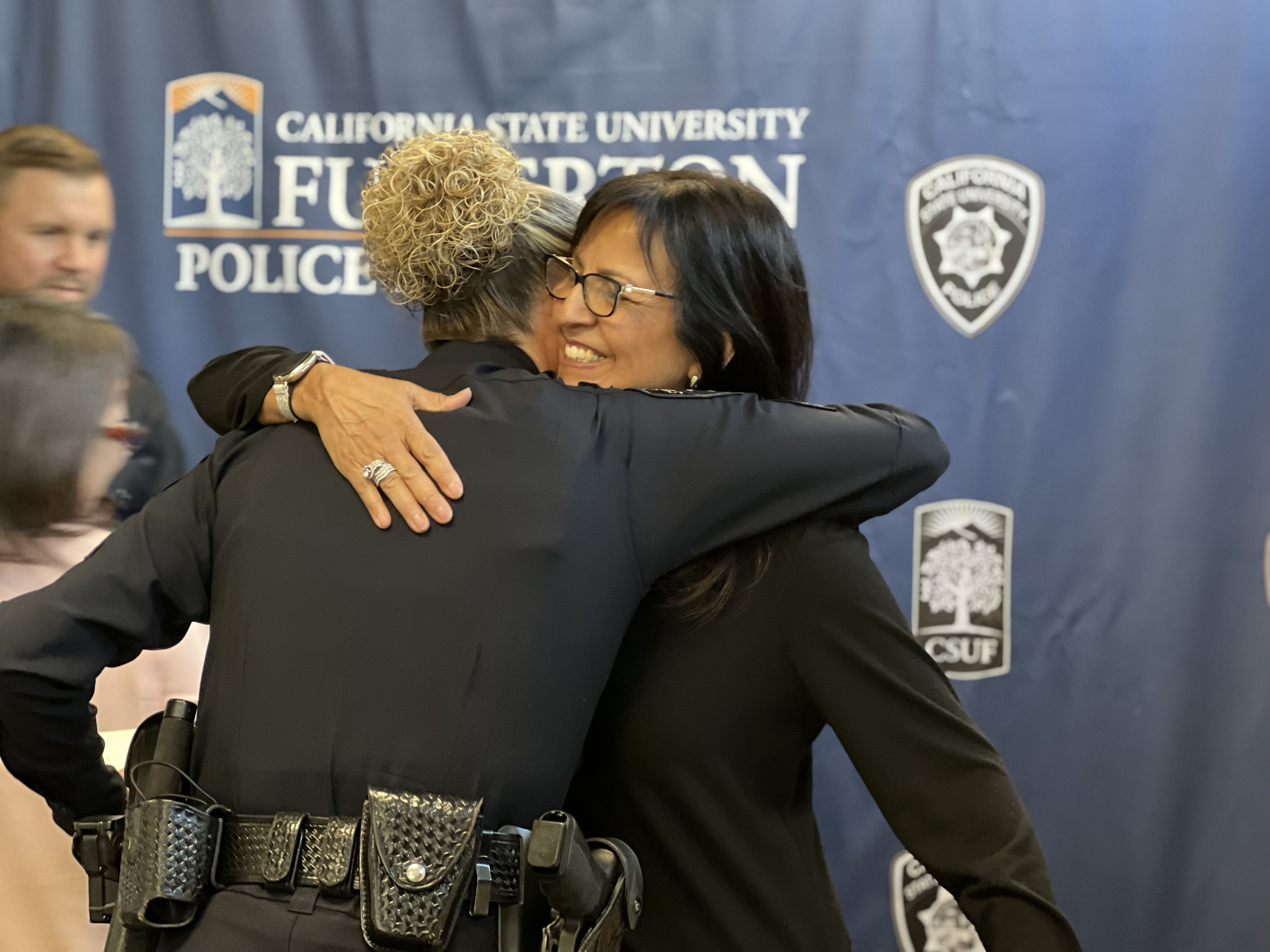 Corporal Hollyfield and ASC employee embrace after recieving lifesaving awards for saving the life of a co-worker