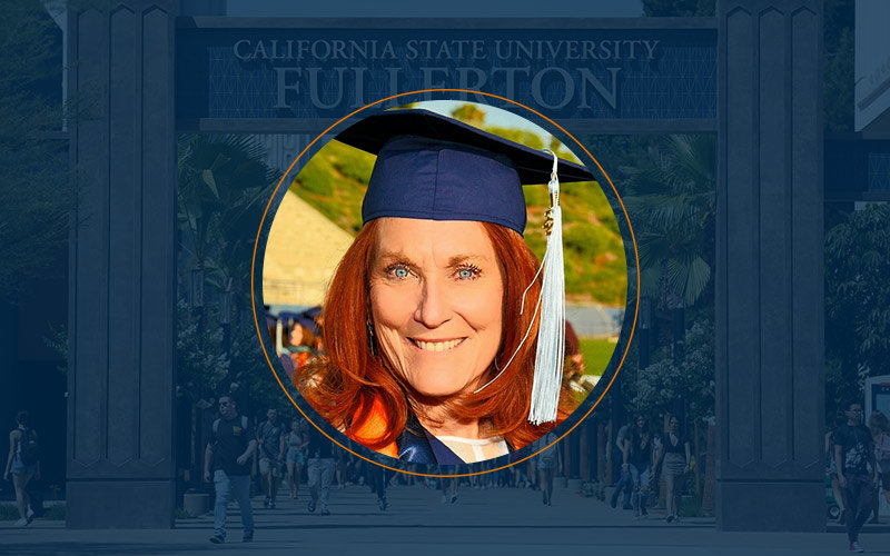 Female adult, with red hair and blue eyes, wearing a blue cap and gown
