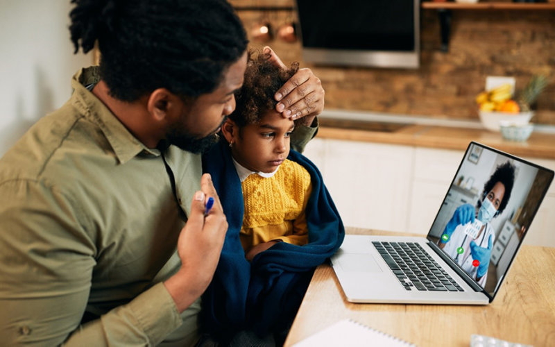 Adobe Stock photo showing a father and daughter in a telemedicine appointment