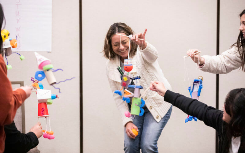 Student manipulates puppet in classroom.