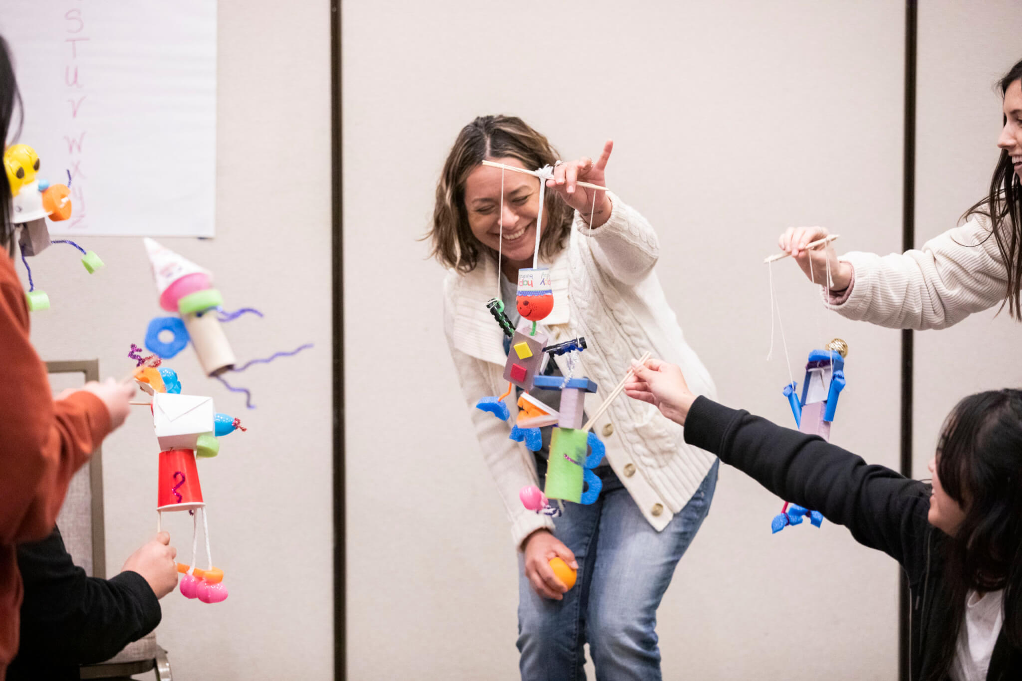 Student manipulates puppet in classroom.