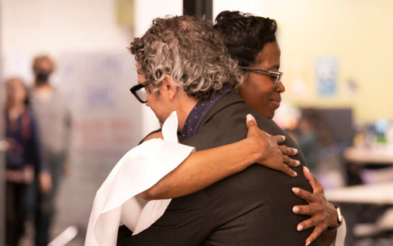 Center Director Romarilyn Ralston hugs Project Rebound's Brady Heiner at the opening of the Center for Hope and Redemption.