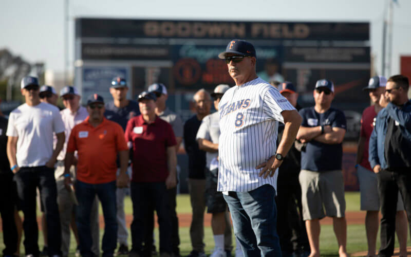 man wearing baseball uniform standing at a baseball stadium