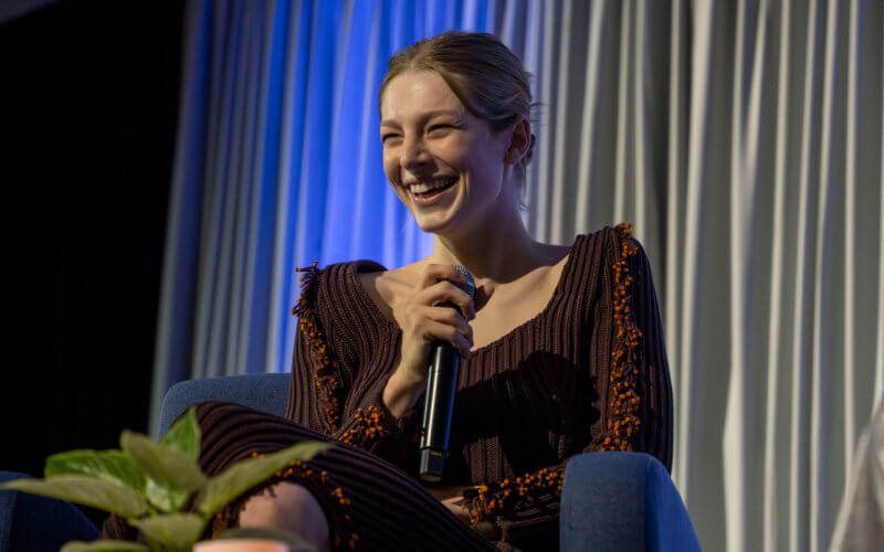 Hunter Schafer smiles while holding microphone